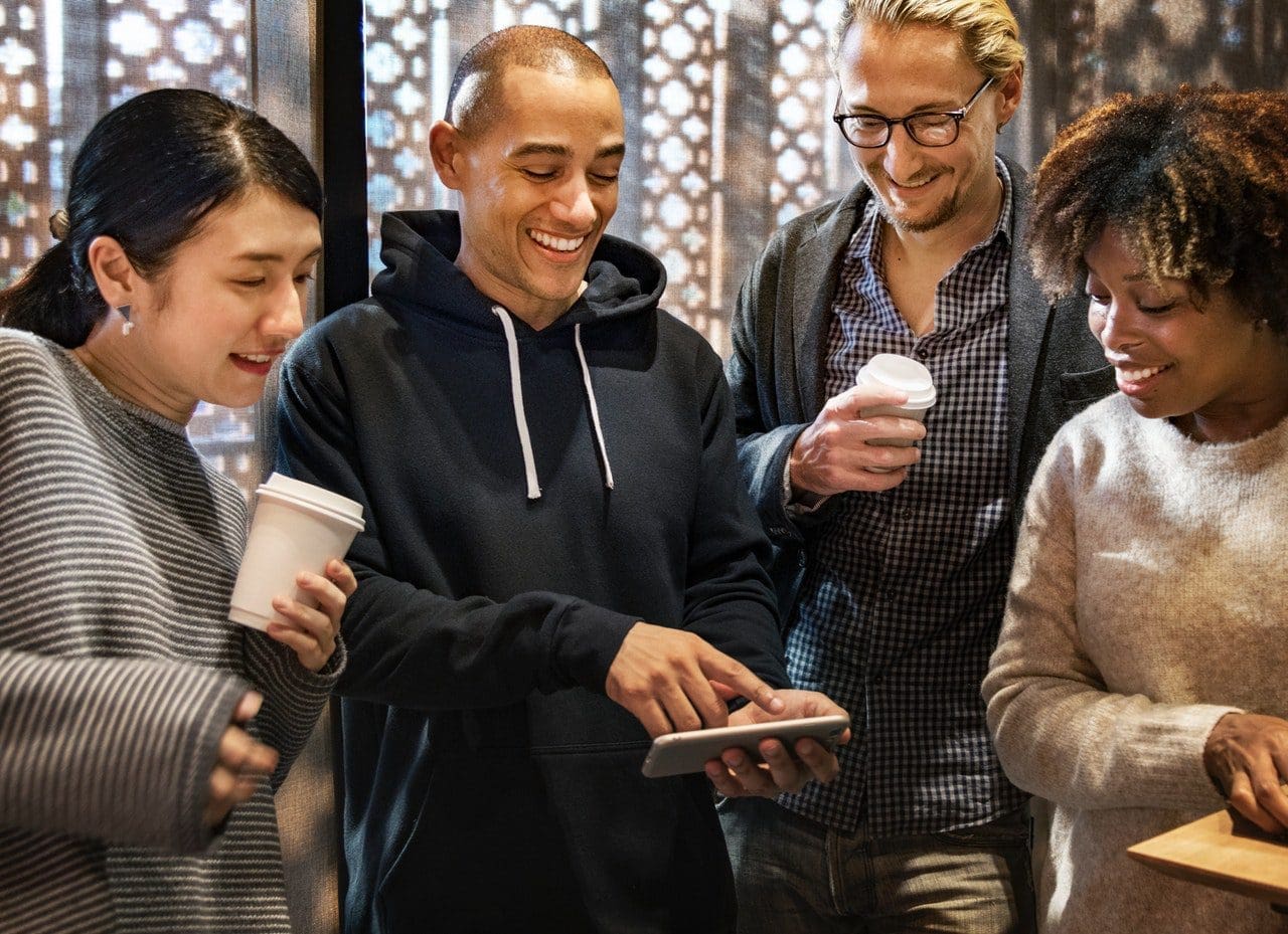 Group looking at mobile phone photo for Google first page post